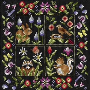 May include: A black cross-stitch embroidery design featuring four squares with different animals and floral patterns. The top left square shows a brown rabbit in a field of purple flowers. The top right square shows a brown bird perched on a nest with three eggs. The bottom left square shows a raccoon in a field of white flowers. The bottom right square shows a squirrel in a field of red flowers.