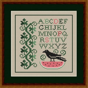 May include: Cross-stitch pattern featuring the alphabet, a black crow perched on a slice of watermelon, and a green leafy vine design.