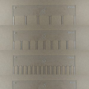 May include: Four clear plastic rulers with different sized teeth. The rulers are labeled with the following measurements: 47mm, 30mm, 17mm, and 8mm.