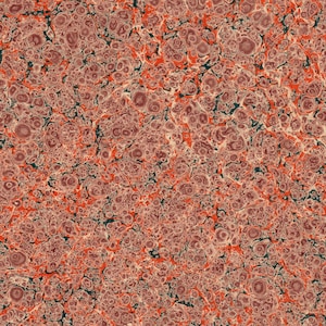 May include: A close-up of a marbled paper with a red, orange, and green color scheme. The paper has a swirling pattern with small, round shapes.