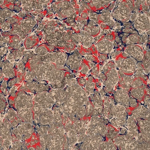 May include: A close-up of marbled paper with a swirling pattern of red, blue, and grey. The paper has a textured surface and a unique, abstract design.