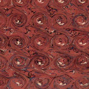 Puede incluir: Papel rojo marmoleado con un patrón de espiral. El papel tiene un patrón repetitivo de círculos blancos con un centro rojo más oscuro.