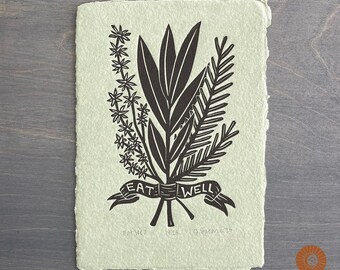 Może przedstawiać: Czarno-biały wydruk linorytu przedstawiający bukiet kwiatów z banerem z napisem "Eat Well". Druk jest podpisany i datowany "Eat Well 14/25 9.Greene'20".