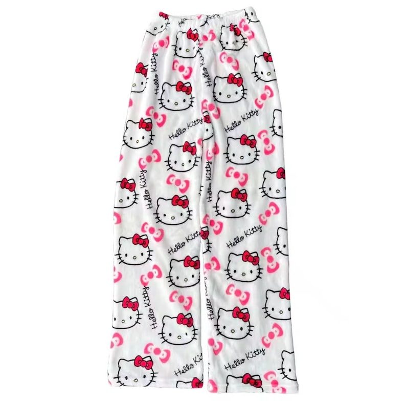 Puede incluir: Pantalones de pijama blancos con un estampado repetido de caras de Hello Kitty con lazos rojos y detalles en rosa. Las palabras "Hello Kitty" est&aacute;n impresas en cursiva. Los pantalones tienen cintura el&aacute;stica.
