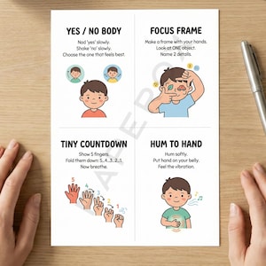 May include: A white card with four illustrated mindfulness exercises for children. The exercises include instructions and illustrations of children. A silver pen rests on the wooden surface next to the card.