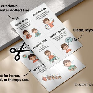 May include: Two white sheets with illustrations and text about mindfulness exercises, including "Bubble Hands" and "Rainbow Scan." The sheets are being cut with scissors. Text includes "Print, cut down the center dotted line."