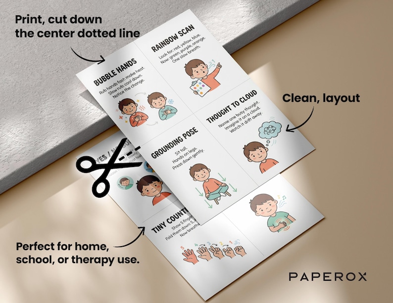 May include: Two white sheets with illustrations and text about mindfulness exercises, including "Bubble Hands" and "Rainbow Scan." The sheets are being cut with scissors. Text includes "Print, cut down the center dotted line."