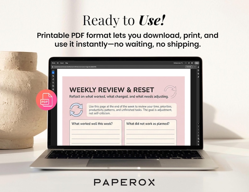 May include: A laptop screen shows a pink and white weekly review template with prompts for reflection. The text on the screen reads "WEEKLY REVIEW & RESET". The image also features the text "Ready to Use!" and "PAPEROX".
