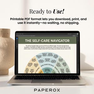 May include: A laptop displays "THE SELF-CARE NAVIGATOR" graphic, a circular diagram with sections for well-being. The screen is open on a desk with a beige vase. Text reads "Ready to Use!" and "Printable PDF format lets you download, print, and use it instantly".