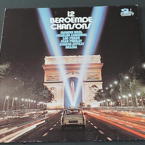 May include: Vintage vinyl record album cover titled "12 Beroemde Chansons" featuring Jacques Brel, Charles Aznavour, and others. The cover art depicts the Arc de Triomphe in Paris at night, with light trails from passing cars and bright spotlights.