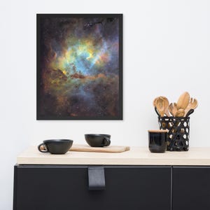 Könnte beinhalten: Gerahmter Kunstdruck mit einem lebendigen Nebel mit wirbelnden Blau-, Gelb- und Orangetönen vor einem dunklen Hintergrund. Der Druck wird über einem schwarzen Schrank mit zwei schwarzen Tassen, einem Holzschneidebrett und Küchenutensilien angezeigt.