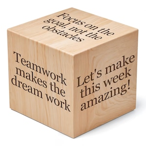 May include: Wooden cube with four inspirational quotes: "Focus on the goal, not the obstacles", "Teamwork makes the dream work", "Let's make this week amazing!"
