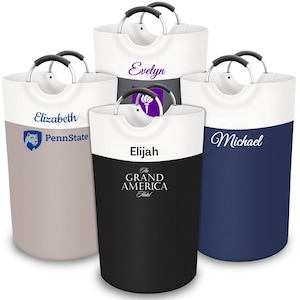 May include: Four white canvas laundry hampers with black metal handles. Each hamper has a different design and name: Elizabeth PennState, Elijah The Grand America Hotel, Evelyn, and Michael.