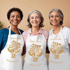 May include: Three white aprons featuring a gold graphic of two hands holding a cross surrounded by small icons of buildings, butterflies, and people. The text Church Name and Blessed to Serve is printed in gold on each apron.