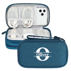 May include: Teal travel tech organizer with multiple compartments for cables, chargers, and a smartphone. The zippered case features the name "Oliver" with a large initial "O" in white on the front.
