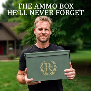 May include: An olive green ammo box with a gold monogram and the name "Richard" is held by a person. The text at the top of the image reads "THE AMMO BOX HE'LL NEVER FORGET". The box has a latch closure and is likely made of metal.
