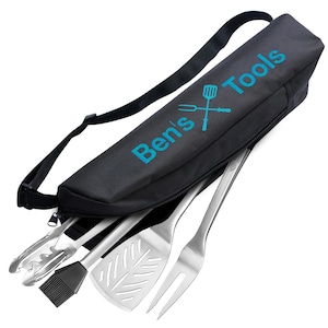 May include: A black carrying case with the text "Ben's Tools" in teal, containing stainless steel grilling tools. The set includes tongs, a basting brush, a spatula, and a fork. The case has a black shoulder strap.