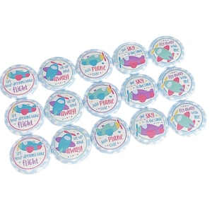 May include: A set of 12 blue and white round buttons with airplane designs and text. The text on the buttons includes "Let your dreams take flight", "We up and away!" and "Just Plane Cute".