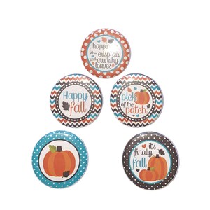 May include: Five round buttons with fall-themed designs. The buttons feature orange, brown, blue, and white colors. The text on the buttons reads "happin is... crisp air and crunchy leaves", "Happy fall", "pick of the patch", "it's finally fall", and a pumpkin.