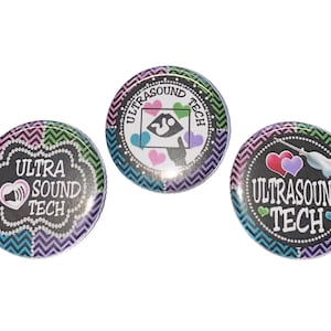 May include: Three round buttons with a black background and colorful chevron patterns. The buttons feature the text "Ultra Sound Tech" with a heart and a medical symbol.