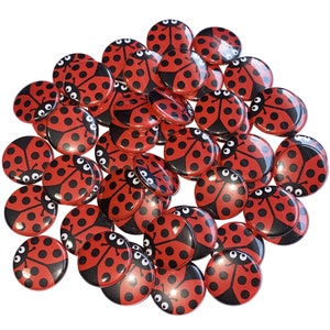 May include: A large group of red and black ladybug buttons. The buttons are round and have a shiny finish.