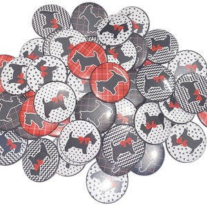 May include: A collection of round, black and white, and red and white buttons with a silhouette of a Scottish Terrier dog wearing a red bow. The buttons have different patterns, including polka dots, plaid, and zigzags.