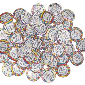 May include: A collection of colorful round buttons with inspirational quotes and bible verses. The buttons feature a rainbow design with flowers and polka dots. The text on the buttons includes phrases like "Pray Without Ceasing", "She is Clothed with Strength and Dignity", "Be Still and Know", and "You are Altogether Beautiful".