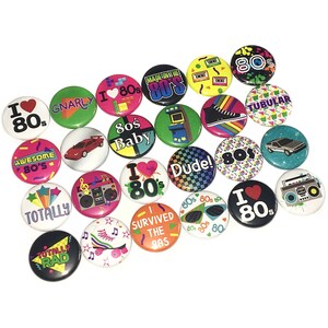 May include: A collection of 20 colorful 80s themed button pins. The pins feature various designs and text, including "I Love 80s", "Totally Rad", "Gnarly", "80s Baby", "Dude!" and "I Survived the 80s".
