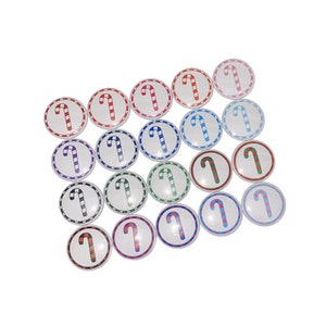 May include: A collection of 18 round, white, candy cane themed buttons with red, green, blue, and black stripes.