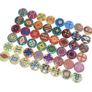May include: A collection of 30 colorful round buttons featuring Native American inspired geometric designs. The buttons are made of metal and have a shiny finish.