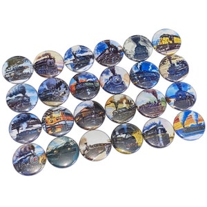 May include: A collection of 20 round buttons featuring colorful images of vintage steam locomotives. The buttons are arranged in a semi-circle pattern on a white background.