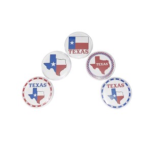 May include: Five round, white, button-style pins with a Texas theme.  Each pin features a different design of the Texas state flag or outline of the state with the word "TEXAS" printed on each pin.