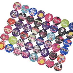 May include: A collection of colorful round buttons with various field hockey-themed designs. The buttons feature phrases like "Peace Love Hockey", "Field Hockey Cutie", "Girls Field Hockey Rocks", and "Eat Sleep Hockey".