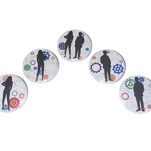 May include: A collection of five white round buttons. Each button features a black silhouette of a person or people, surrounded by colorful gears, geometric shapes, and mathematical symbols. The buttons are arranged in an arc.