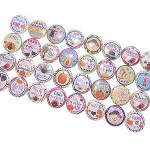 May include: A collection of 25 colorful round buttons with various autumn-themed designs and sayings. The buttons feature images of pumpkins, turkeys, scarecrows, and other fall icons. Some of the sayings include "Happy Fall Y'all", "Sweet as Pie", and "Fall is in the Air".