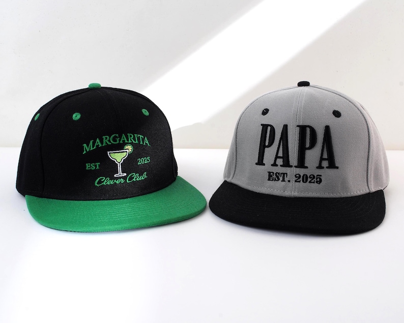 May include: Two black and green baseball caps with embroidered text. One cap says "Margarita Est. 2025 Clever Club" with a green margarita glass graphic. The other cap says "Papa Est. 2025".