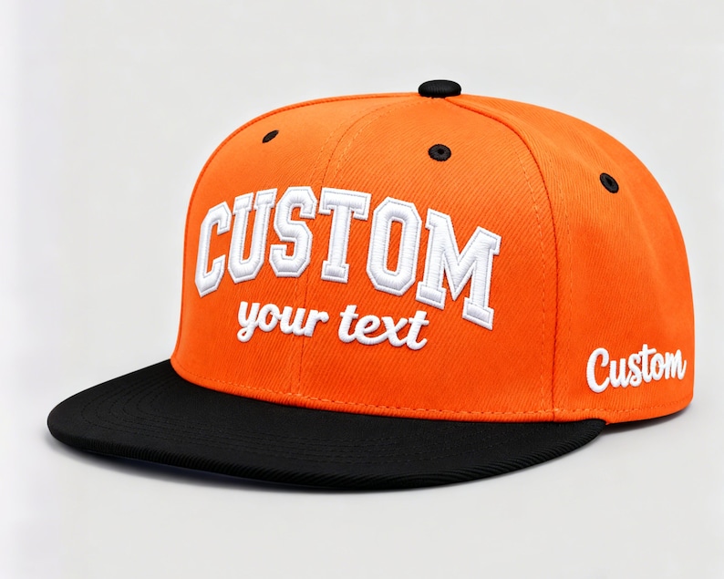 May include: An orange and black custom baseball cap. The cap features the word "CUSTOM" in white, outlined in a collegiate font, with the words "your text" below. The brim is black, and the word "Custom" is on the side.