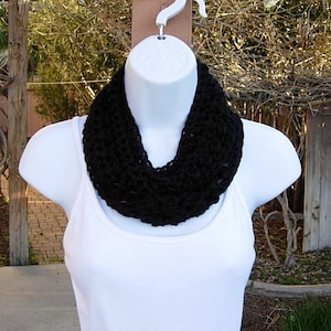May include: A black crocheted infinity scarf worn on a white mannequin.