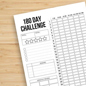 Pode incluir: Uma folha de rastreamento em papel branco com o título 180 DAY CHALLENGE em texto preto. Possui uma grade para 180 dias, uma seção para dois totais, cinco ícones de estrela para avaliação, cinco caixas de seleção circulares e um campo.
