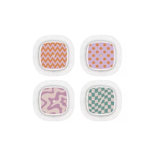 Op de afbeelding: Vier zelfklevende pleisters met patronen. De patronen omvatten oranje zigzags, paarse stippen, een golvend ontwerp in roze en paars en een groen-wit dambordpatroon. Elke pleister heeft een witte, getextureerde rand.