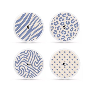 Può includere: Quattro cerotti adesivi rotondi con motivi decorativi. I disegni includono strisce zebrate blu, macchie leopardate blu, scarabocchi blu e pois blu. Ogni cerotto ha un piccolo dettaglio centrale in bianco e nero.