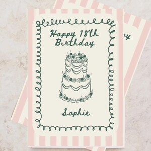 Könnte beinhalten: Geburtstagskarte mit rosa-weiß gestreiftem Rand und grünem Zierrahmen. Die Karte zeigt eine Kuchenillustration und den Text "Happy 18th Birthday" und "Sophie". Auf der Oberseite der Karte steht "Passe eine Geburtstagskarte an".