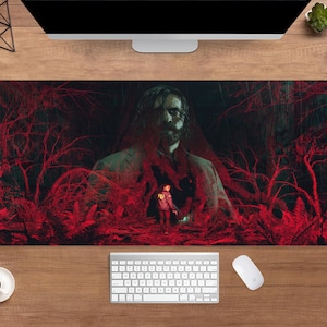 Pode incluir: Tapete de mesa retangular com um design artístico escuro. A obra apresenta uma figura central e uma pessoa com um casaco vermelho, sobre um fundo vermelho e preto com tema de floresta. Um teclado e um rato são visíveis.