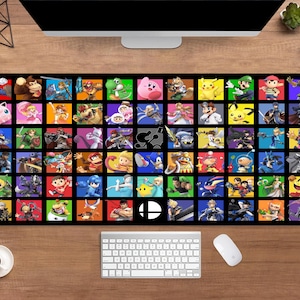 May include: Black rectangular desk mat featuring a grid of colorful squares, each displaying a character from the Super Smash Bros. video game series. The mat includes a white keyboard, mouse, and a coffee cup.