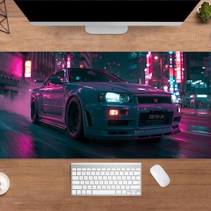 May include: A rectangular desk mat featuring a blue sports car speeding through a neon-lit city at night. The car has its headlights on and the license plate reads "TOKYO-34". The background is a blur of pink and purple lights.