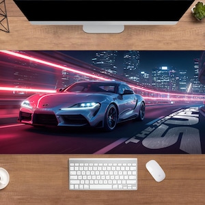 Pode incluir: Um tapete de mesa retangular com um carro esportivo prateado correndo em alta velocidade em uma estrada iluminada por néon à noite. O fundo mostra uma paisagem urbana com luzes brilhantes. O texto "THE ICON SUPRA" é visível.