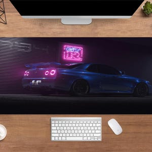 May include: A blue sports car mousepad featuring a blue car with a spoiler, illuminated by neon lights. The neon sign reads "GT-R". The mousepad is rectangular and rests on a wooden desk.