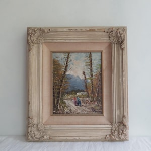 Puede incluir: Pintura al &oacute;leo enmarcada antigua que representa un paisaje de monta&ntilde;a con un camino y figuras. El marco es ornamentado, con un acabado blanquecino envejecido. La pintura presenta una paleta de colores apagados con azules, verdes y marrones.