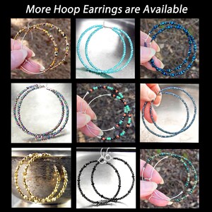 May include: Nine pairs of hoop earrings with different colored beads. The earrings are made with silver wire and have a variety of colors, including gold, blue, green, black, and turquoise.