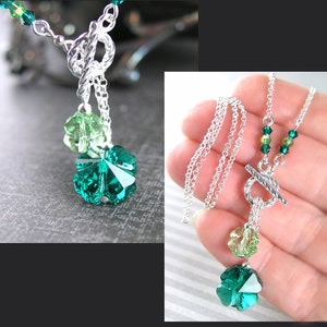 Puede incluir: Un collar de cadena de plata con un dije de tr&eacute;bol verde. El dije est&aacute; hecho de cristal facetado y tiene un degradado de color verde claro a verde oscuro. El collar tiene un cierre de palanca.